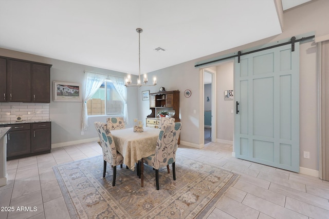 tiled dining area with a notable chandelier and a barn door