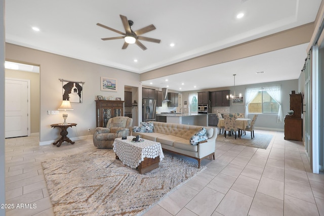 tiled living room with sink and ceiling fan with notable chandelier