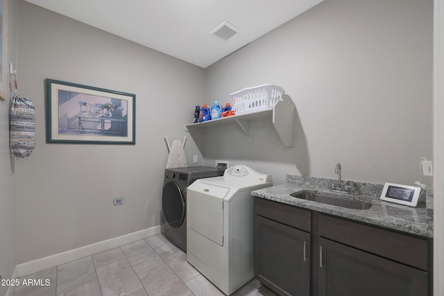 washroom with cabinets, separate washer and dryer, and sink