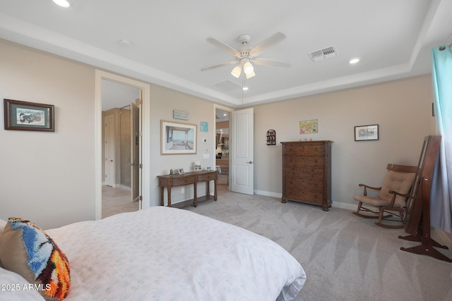 carpeted bedroom with a raised ceiling and ceiling fan