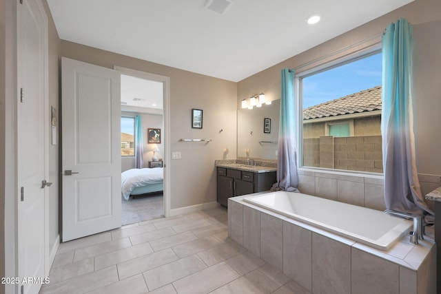 bathroom featuring vanity, a relaxing tiled tub, and tile patterned floors