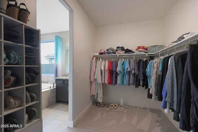 walk in closet with light tile patterned flooring and lofted ceiling