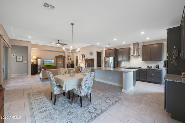 tiled dining space featuring ceiling fan with notable chandelier