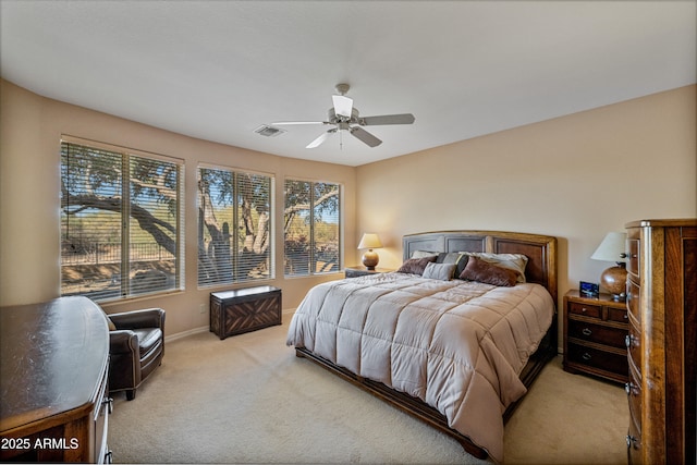 bedroom with ceiling fan, light carpet, and multiple windows