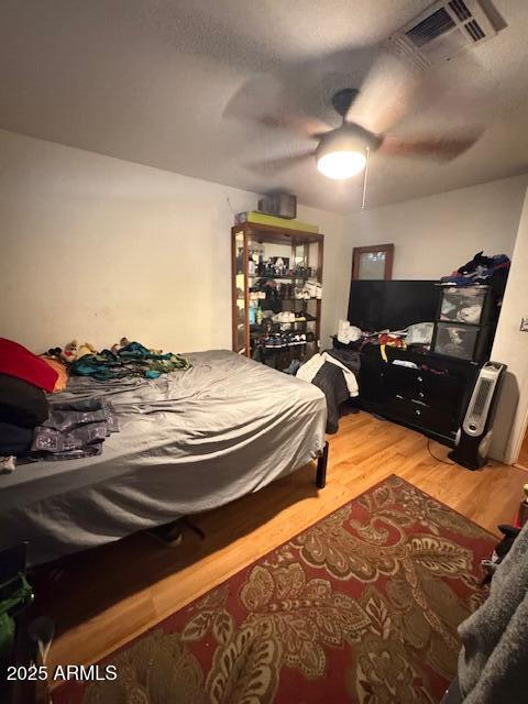 bedroom with ceiling fan and hardwood / wood-style flooring