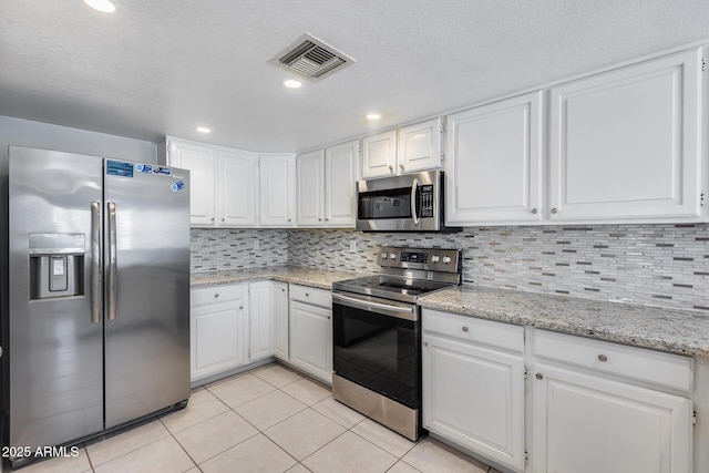 11217 E Laurel Ln, Scottsdale, AZ 85259 - kitchen featuring appliances with stainless steel finishes, white cabinets, light tile patterned floors, decorative backsplash, and recessed lighting