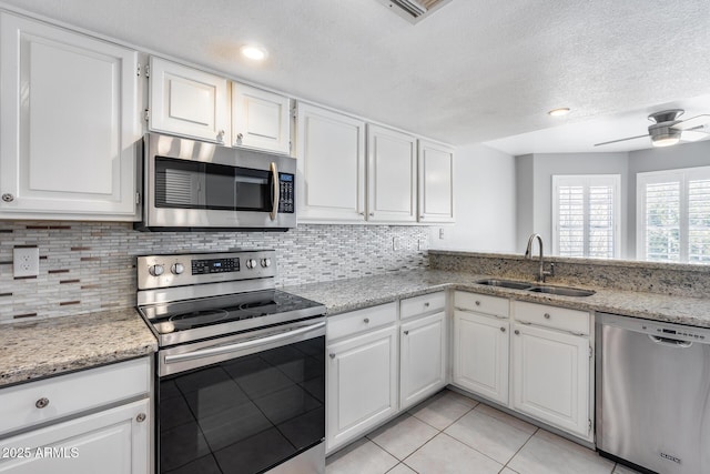 11217 E Laurel Ln, Scottsdale, AZ 85259 - kitchen with appliances with stainless steel finishes, white cabinetry, backsplash, light tile patterned flooring, and a textured ceiling