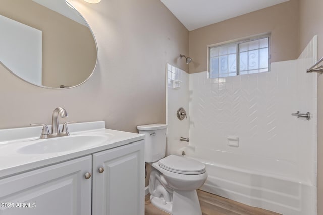 bathroom featuring toilet, tub / shower combination, wood finished floors, and vanity