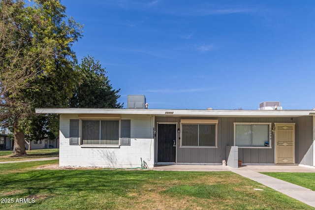 view of front of house featuring a front yard and concrete block siding