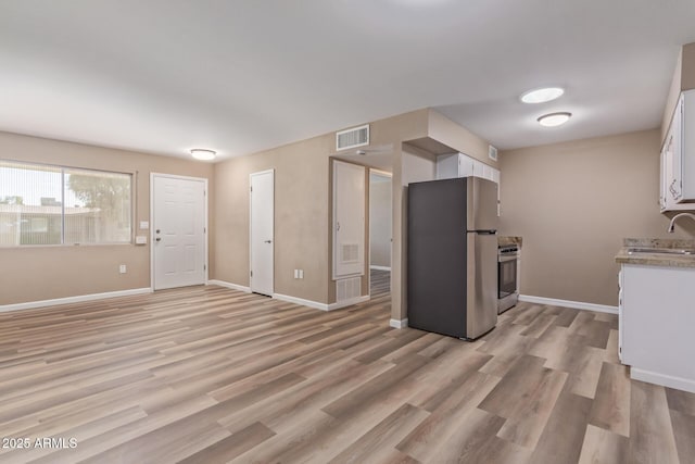 kitchen with visible vents, baseboards, white cabinetry, appliances with stainless steel finishes, and light wood-type flooring