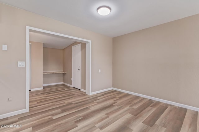 unfurnished room featuring light wood-type flooring and baseboards