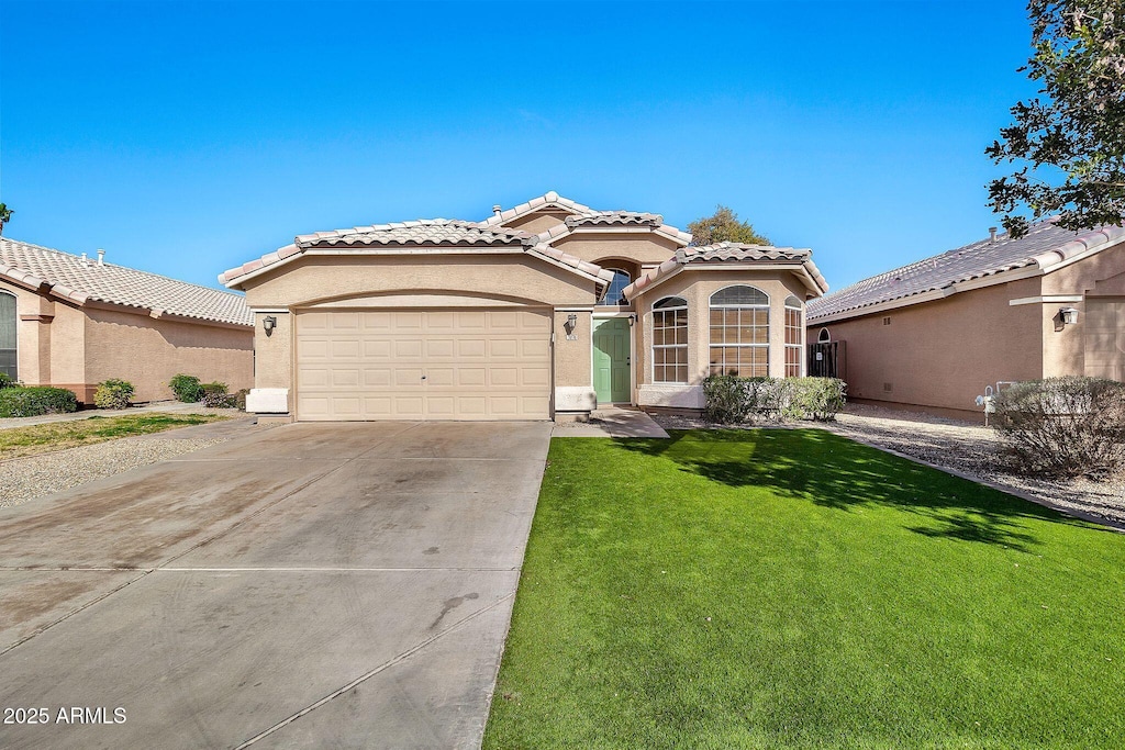 mediterranean / spanish-style home with a garage and a front yard