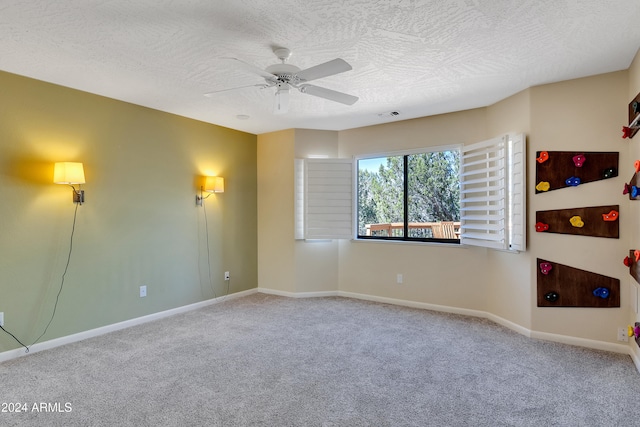 carpeted spare room with a textured ceiling and ceiling fan