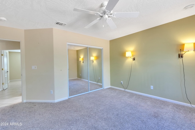 unfurnished bedroom with a textured ceiling, a closet, and ceiling fan