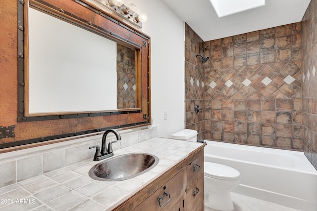 full bathroom with tiled shower / bath, vanity, and toilet