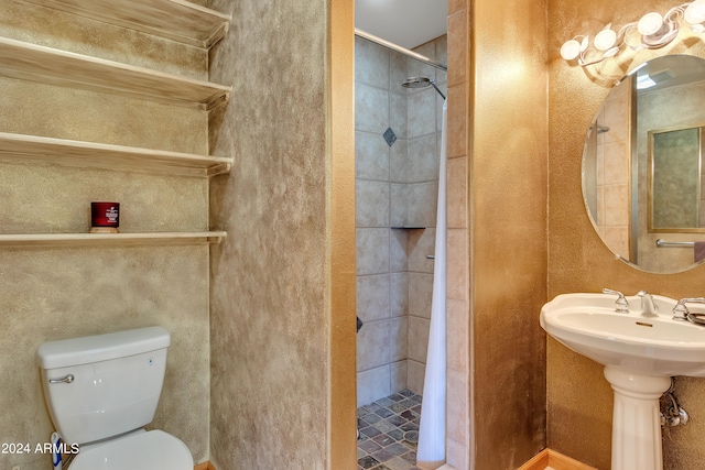 bathroom with sink, a shower with shower curtain, and toilet