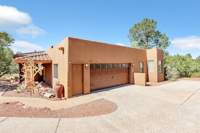 pueblo revival-style home with a garage