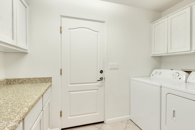 laundry room featuring light tile patterned flooring, cabinets, and washer and clothes dryer