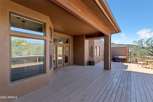 wooden deck with a hot tub