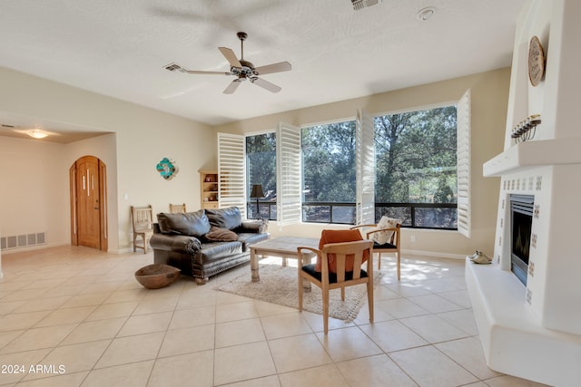 tiled living room with a textured ceiling and ceiling fan