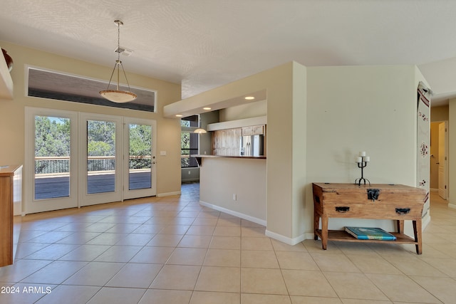 interior space with a textured ceiling and light tile patterned floors