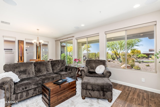 living room with plenty of natural light, hardwood / wood-style floors, and a chandelier