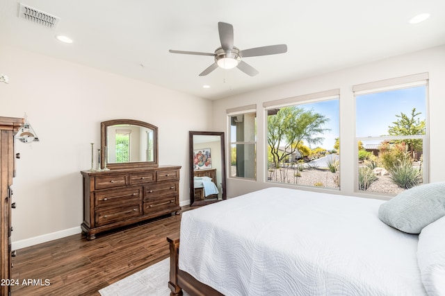 bedroom featuring ceiling fan, dark wood-type flooring, and multiple windows