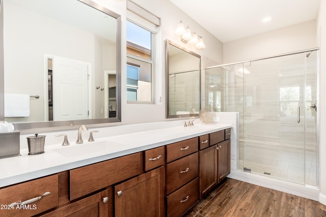 bathroom with walk in shower, vanity, and hardwood / wood-style floors