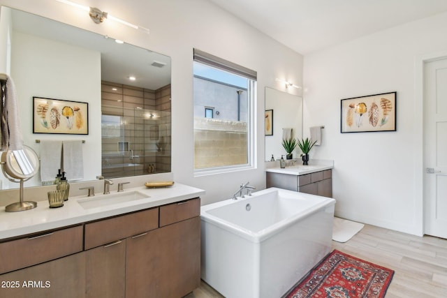 bathroom with vanity, separate shower and tub, and wood-type flooring