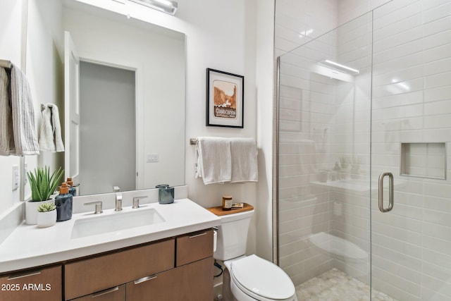 bathroom with vanity, a shower with shower door, and toilet