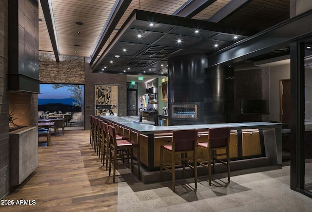 bar with wood-type flooring, wood ceiling, and beam ceiling