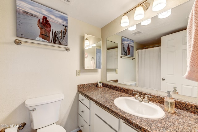 full bathroom featuring a shower with shower curtain, visible vents, vanity, and toilet