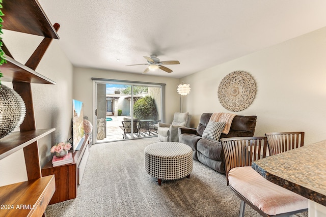 carpeted living room with a textured ceiling and ceiling fan