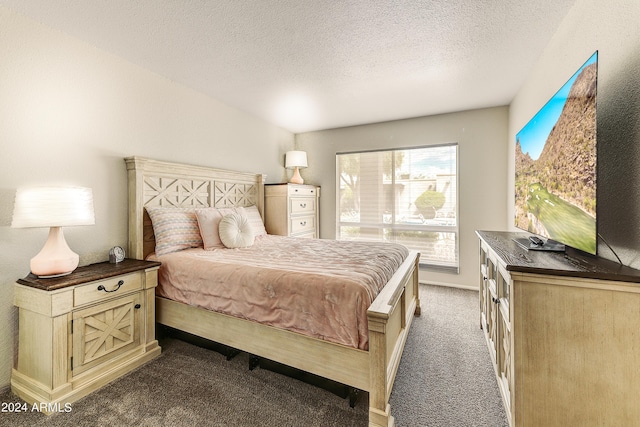 bedroom with a textured ceiling, dark carpet, and baseboards