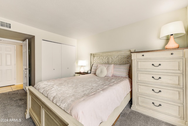 bedroom featuring light carpet, visible vents, and a closet