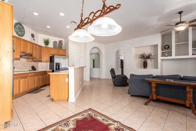 kitchen with pendant lighting, ceiling fan, stainless steel fridge, light tile patterned floors, and a kitchen island