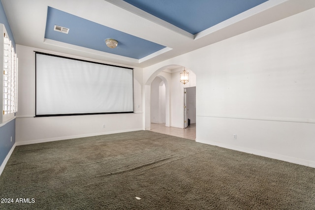 carpeted home theater featuring a tray ceiling