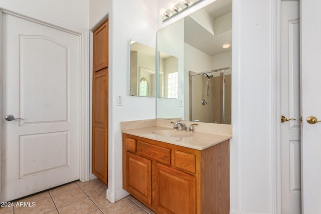 bathroom with tile patterned floors, a shower, and vanity