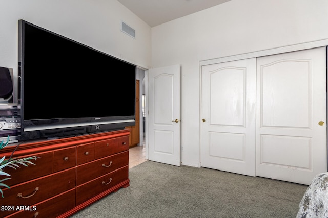 bedroom featuring light colored carpet and a closet