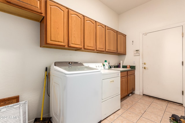 laundry room featuring sink, light tile patterned floors, cabinets, and independent washer and dryer