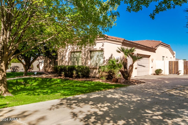 mediterranean / spanish-style house featuring a garage and a front lawn