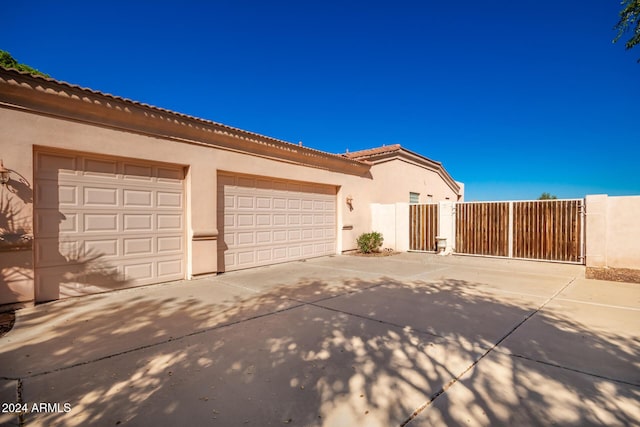 2914 E Gary Way, Phoenix, AZ 85042 - view of front of property with concrete driveway, stucco siding, a gate, a garage, and a tiled roof