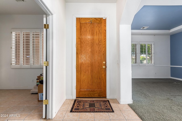 foyer entrance featuring light colored carpet