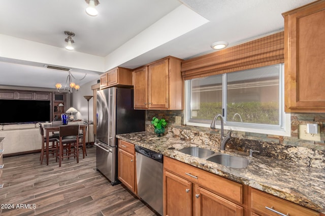 kitchen with backsplash, an inviting chandelier, sink, dark hardwood / wood-style floors, and appliances with stainless steel finishes