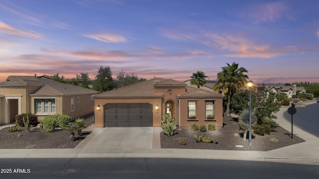 ranch-style home with concrete driveway, stucco siding, a tiled roof, and a garage