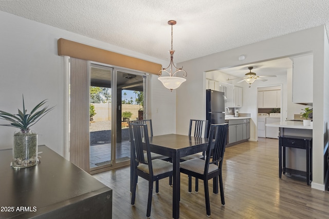 dining space with washing machine and dryer, ceiling fan, a textured ceiling, and wood-type flooring