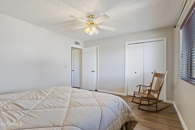 bedroom with ceiling fan, a textured ceiling, hardwood / wood-style flooring, and a closet