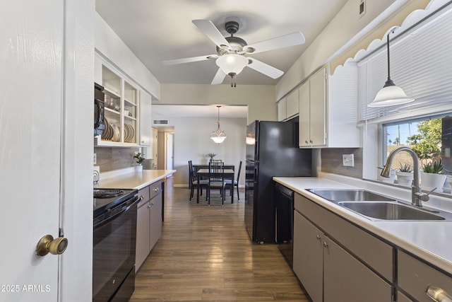 kitchen with sink, pendant lighting, white cabinets, and black appliances