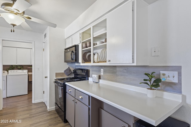 kitchen featuring ceiling fan, independent washer and dryer, light hardwood / wood-style floors, black appliances, and white cabinetry