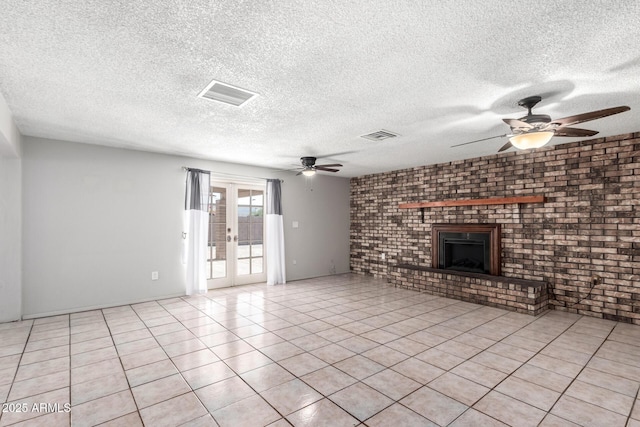 unfurnished living room with ceiling fan, a fireplace, a textured ceiling, light tile patterned floors, and french doors